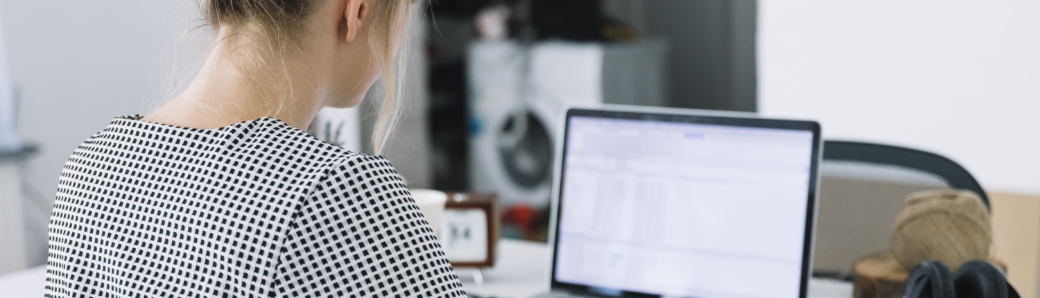 rear-view-businesswoman-writing-notes-brown-paper-with-laptop-desk-min